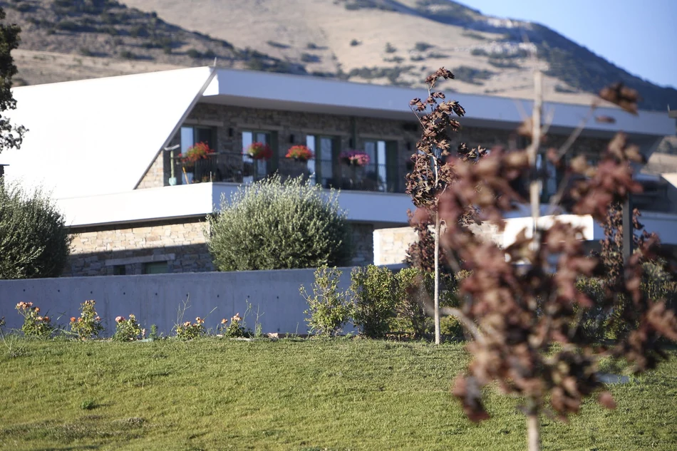 Πτέρυγα διαμερισμάτων με λιθόδομη όψη και ανοιγόμενα κουφώματα αλουμινίου με μπαλκόνια